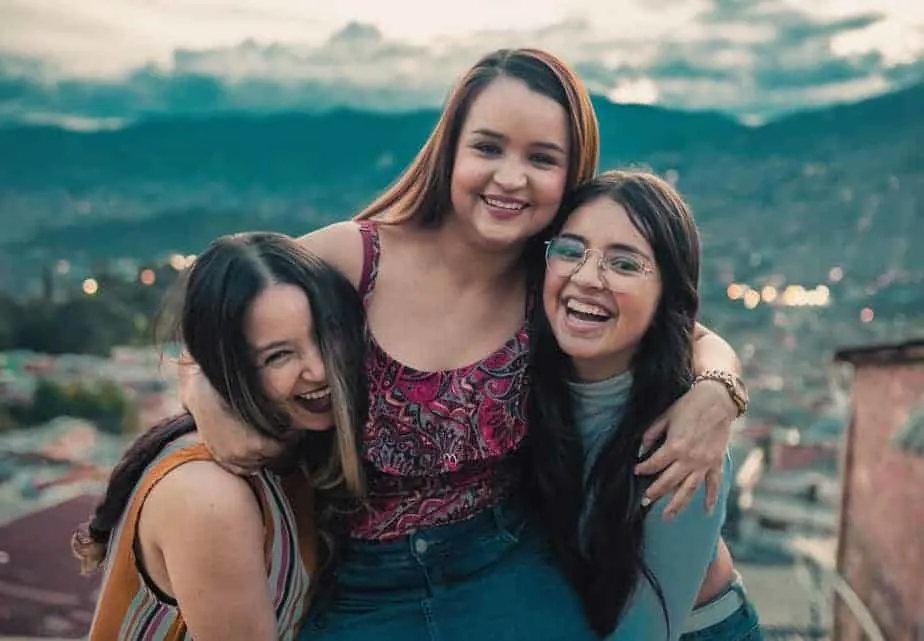 happy young women hugging on rooftop