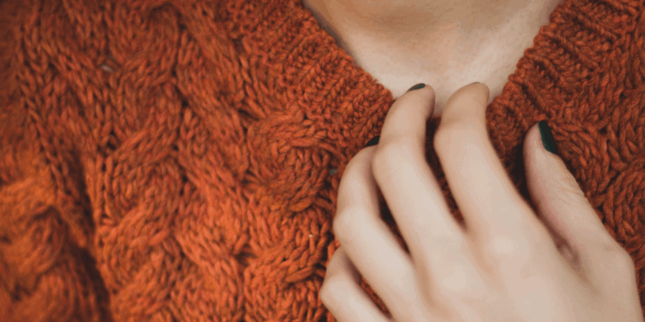 Decorative image of a woman in a brown sweater with her hand to her chest