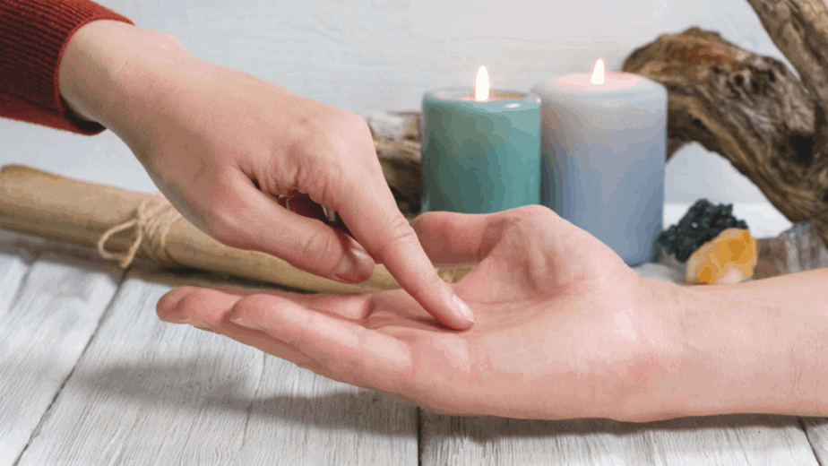 Decorative image of palm reading with pastel colored candles