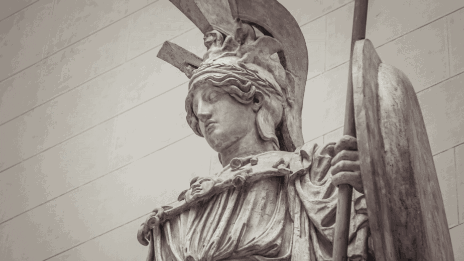 Decorative image of a statue of the Greek goddess Athena in armor and holding a shield and spear
