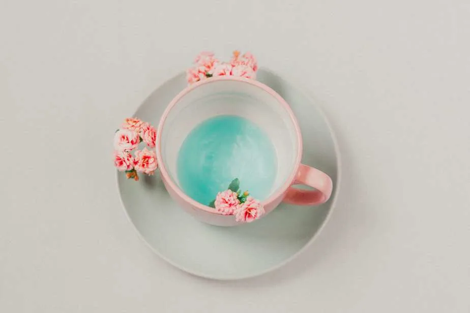 pink cup with blue liquid and pink flowers