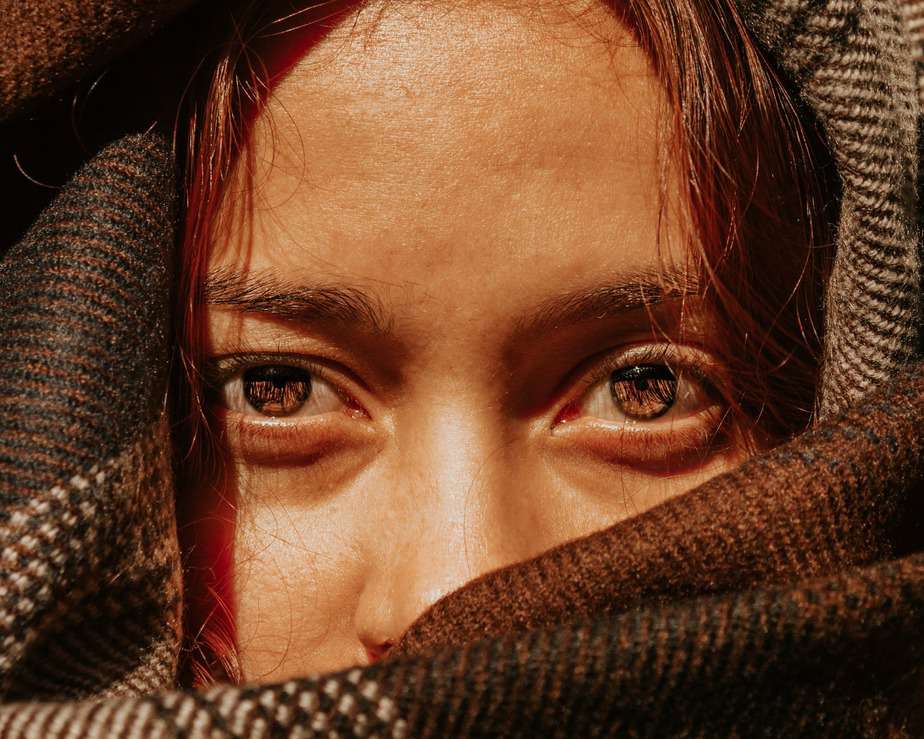 crop young woman with brown eyes in warm scarf