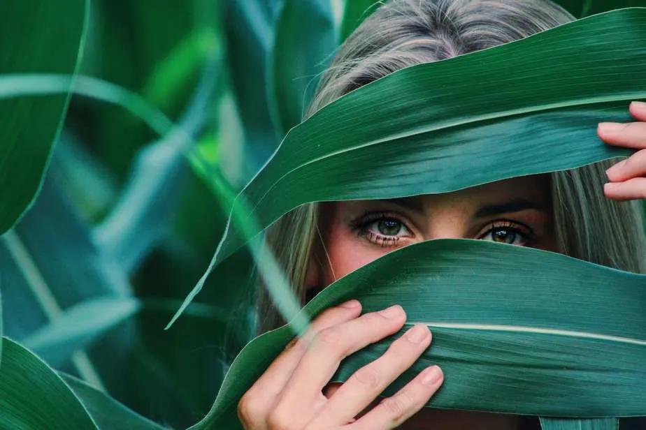 woman covering her face with corn leaves