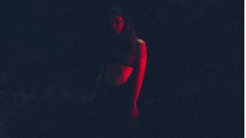 Decorative image of a woman in red in the dark