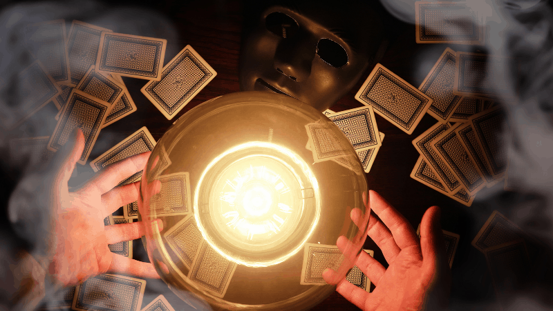 Decorative image of  a psychic's hands, a candle, tarot cards, and a black mask