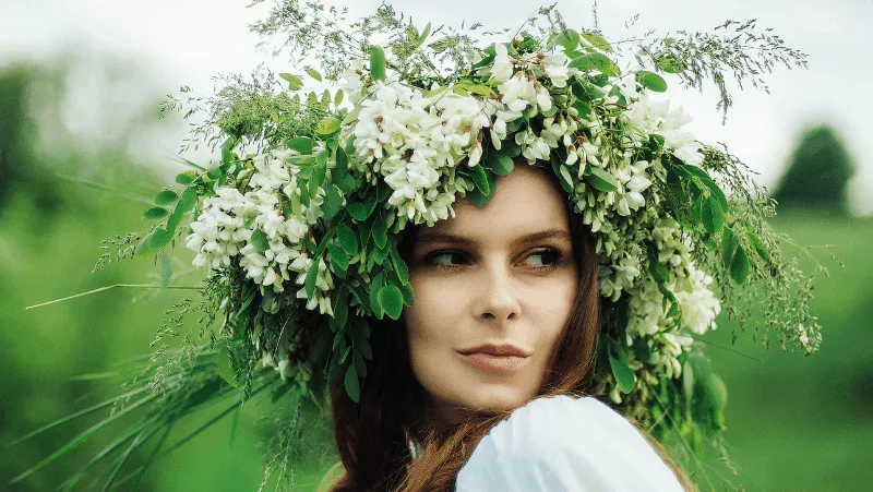 A pagan woman looking to the side and wearing a flower crown.