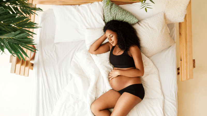 A pregnant woman relaxing in her bed