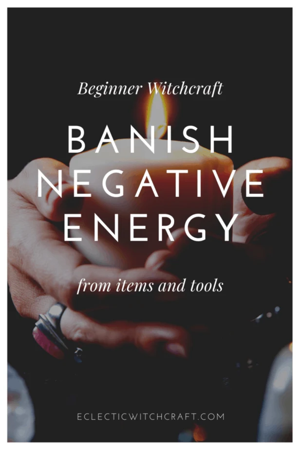 Beginner witchcraft: banish negative energy from items and tools. A witch holding a white candle and wearing jewelry.
