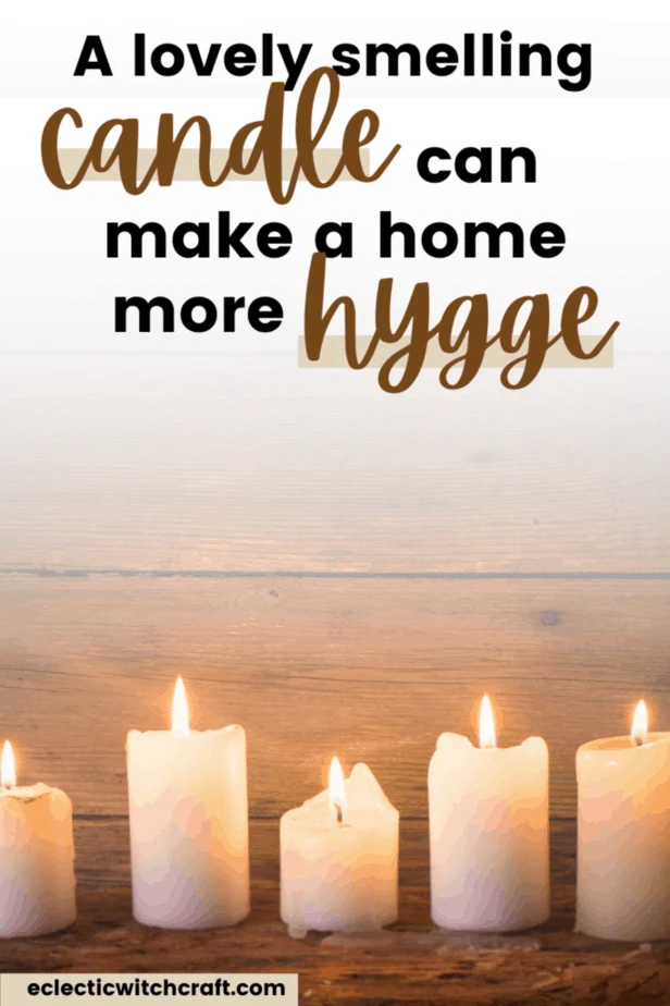 A lovely smelling candle can make a home more hygge. A line of white candles lit with fire against a wooden background.