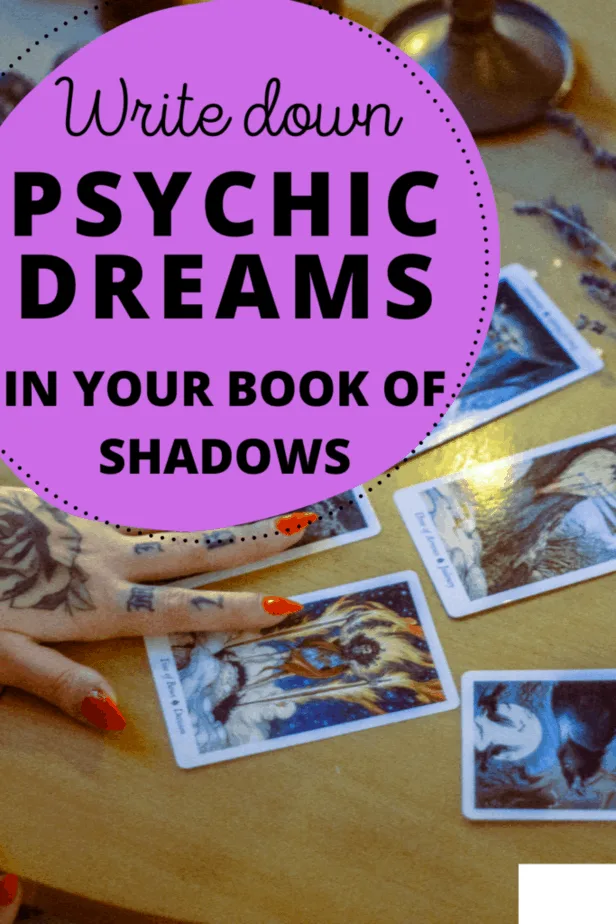 Write down psychic dreams in your book of shadows. A tarot reader with tattoos on her hands and red nails reading tarot cards.