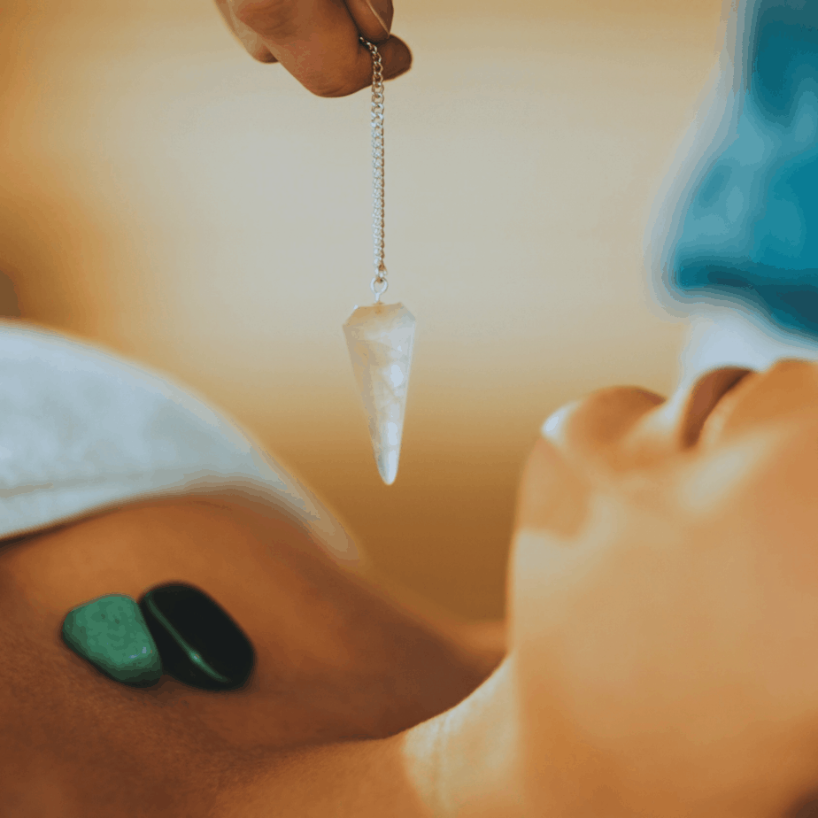 quartz pendulum and stones on the chest of a woman going through spiritual healing