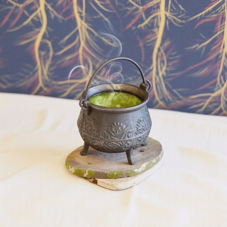 A cute cauldron with a forest backdrop on a white table.