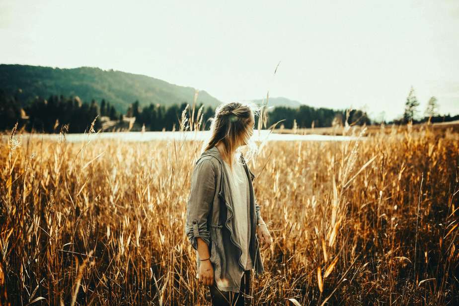 woman standing in the middle of plant field
