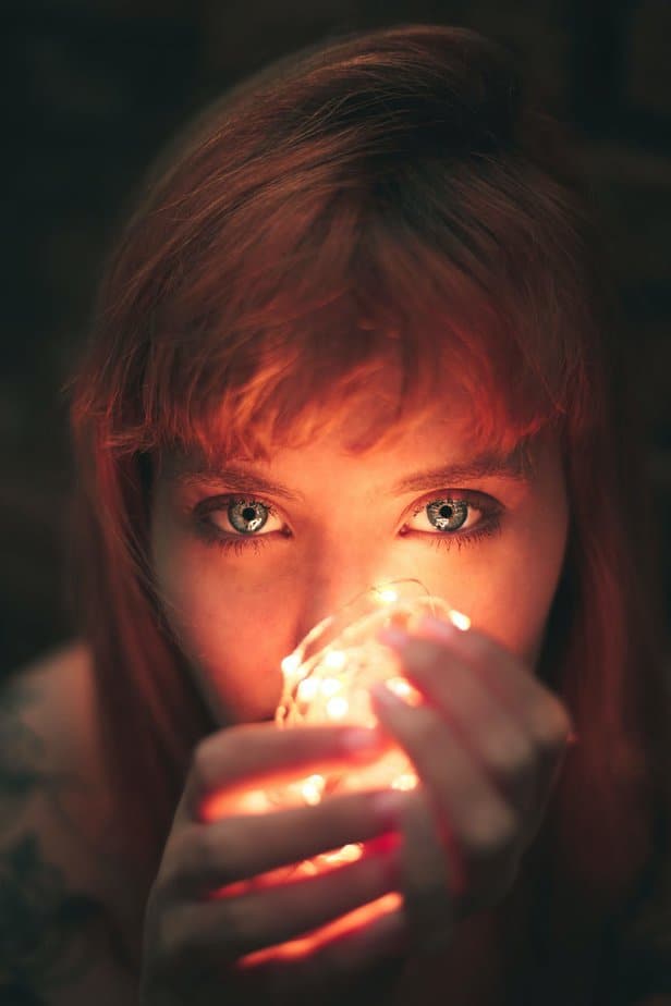 close up photography of woman holding string lights