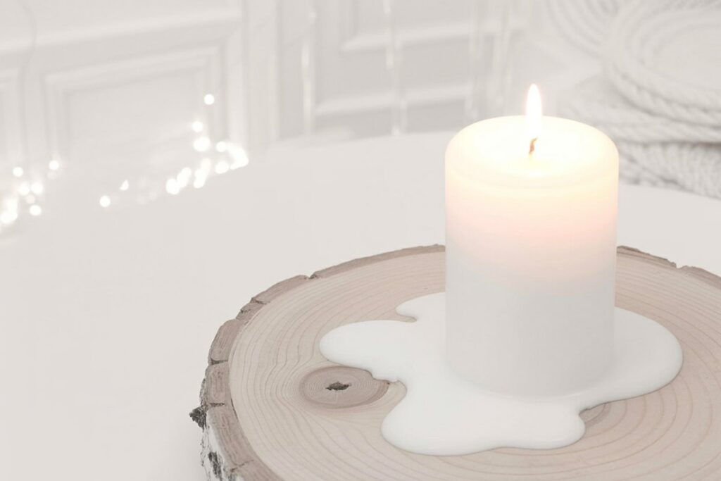 White candle wax pooling on unfinished wood creates indexical proof of practice, not staged photography. The irregular wax drips and wood's visible grain keep the composition grounded in physical reality rather than aesthetic performance. Tree rings in the wood slice connect your candle work to natural cycles and tree growth patterns.