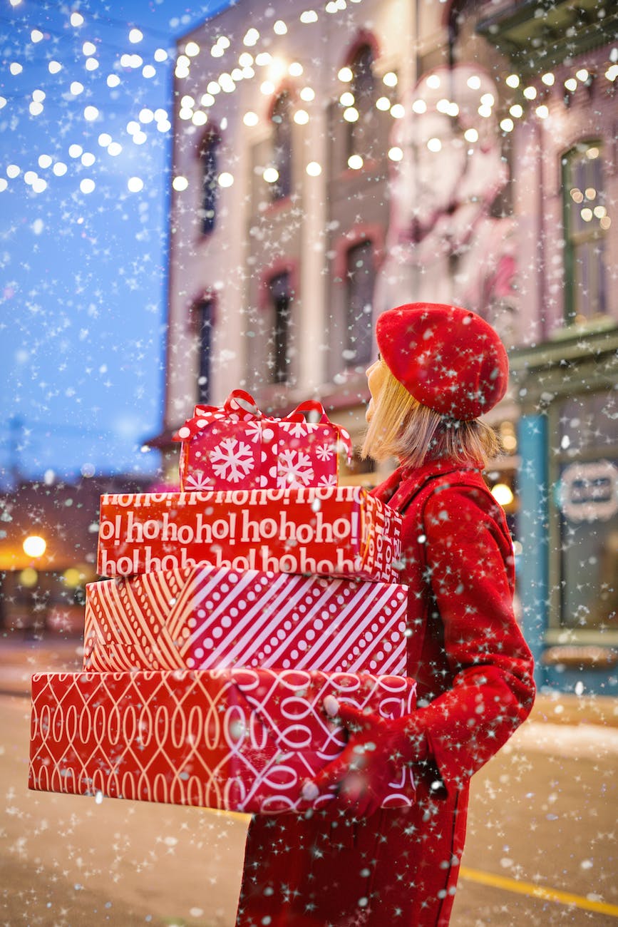 woman holding three red christmas presents boxes