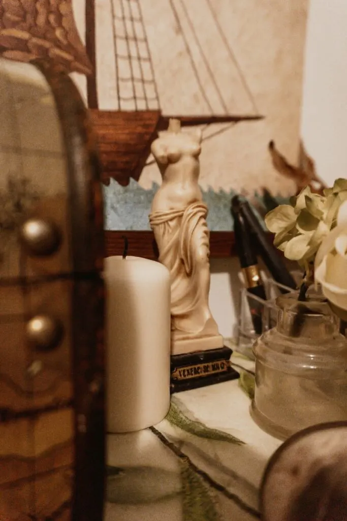 white ceramic angel figurine beside white pillar candle