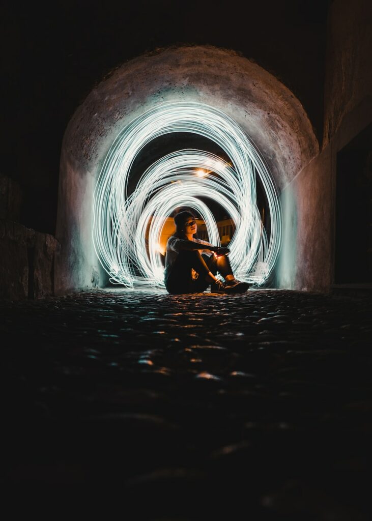 woman in black jacket sitting on tunnel