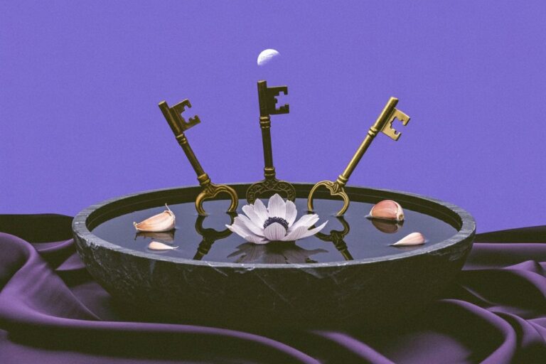 Three ornate brass and bronze skeleton keys rest in a dark ceremonial bowl with floating white anemone and garlic cloves beneath a crescent moon, representing Hekate's role as keeper of keys that unlock hidden knowledge and her connection to lunar cycles and protective magic.